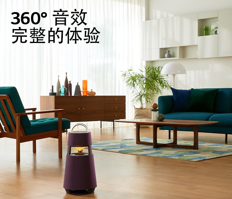 图为一名女子坐在沙发上听音乐，前面放着一台 XBOOM 360。