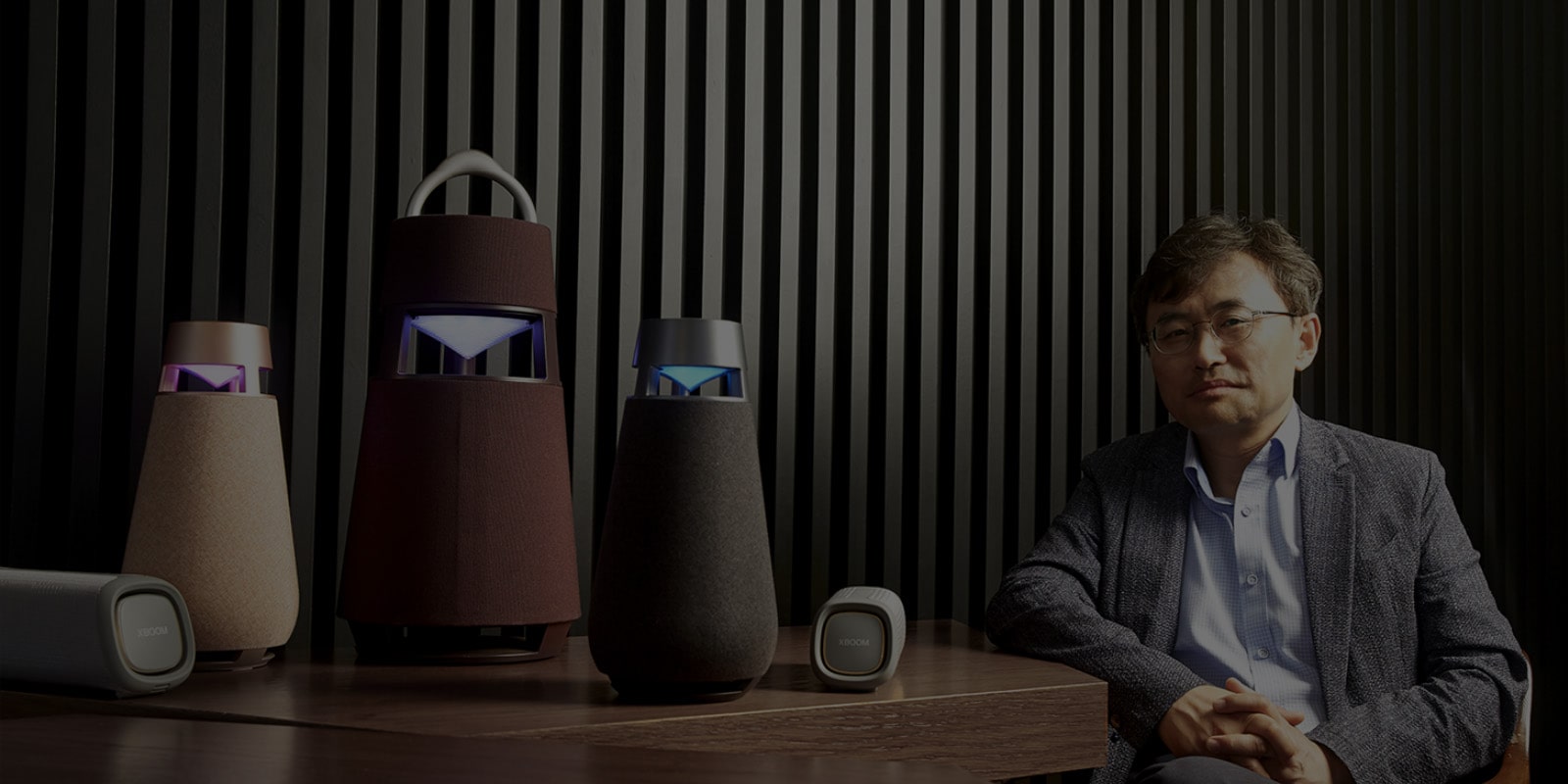 图为韩国照明设计师协会主席 Seungdae Hong 教授与桌子上的 XBOOM 系列产品