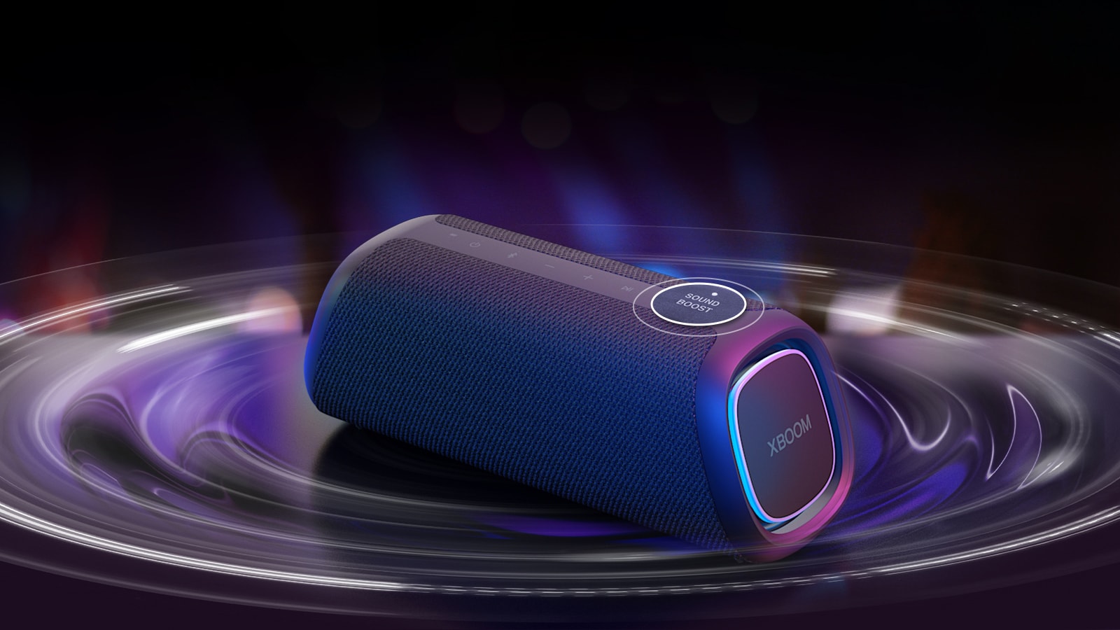 LG XBOOM GO XG7 放置在桌子上。sound Boost 按钮放大，扬声器下有声波效应。播放视频。