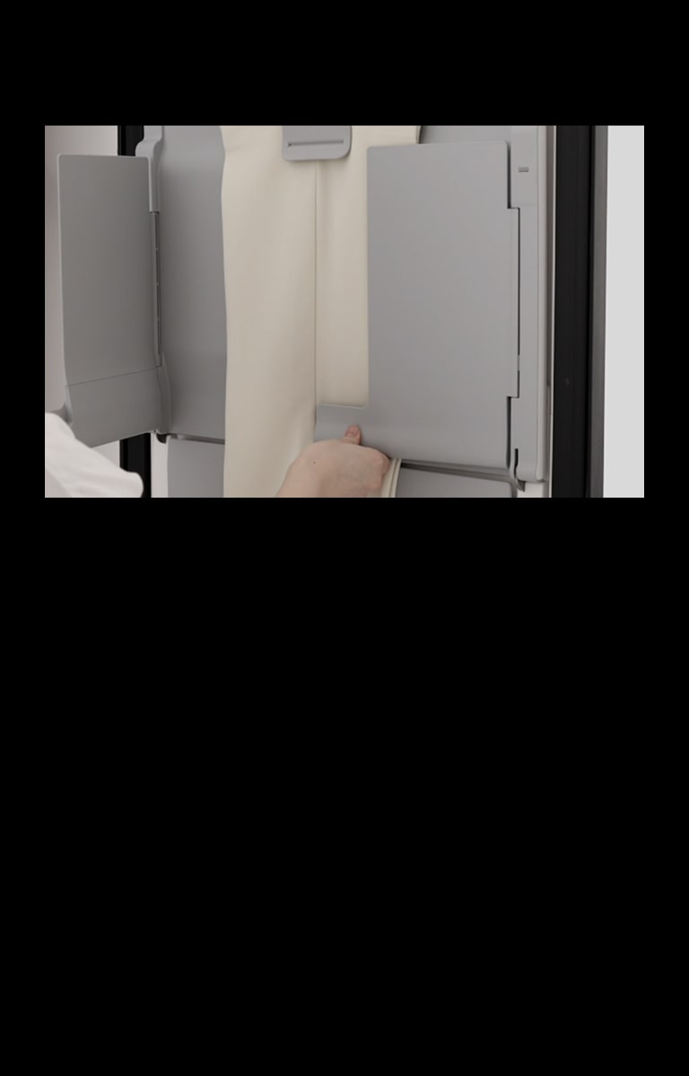 使用 LG Styler 蒸汽衣物护理机多层 EZ Fit PantsPress™ 熨烫机熨平长裤褶皱、恢复裤褶的人。