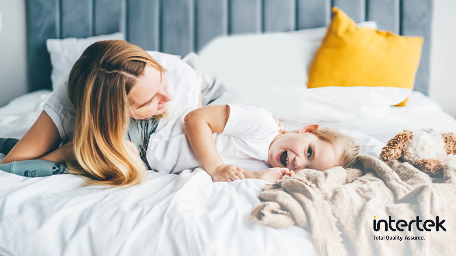 女士和孩子躺在床上笑着