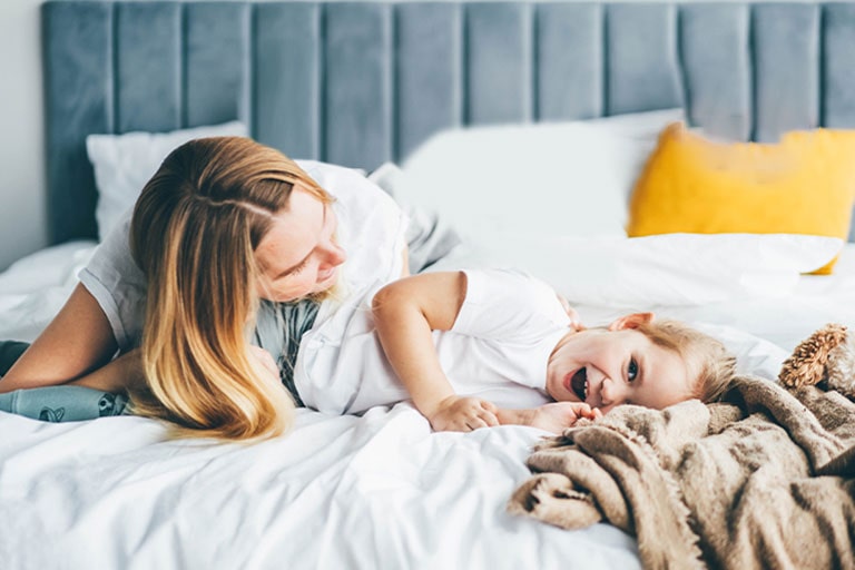 孩子和母亲躺在床上。