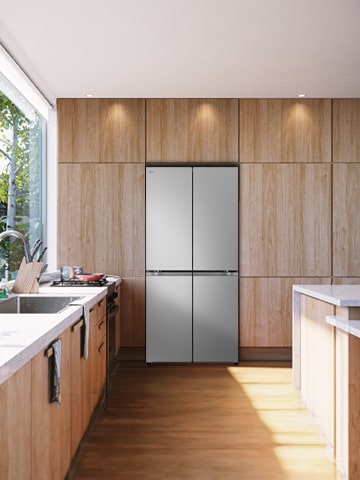 LG refrigerator open with fresh produce in a bright natural wood kitchen, beside a large window with plants and soft daylight.	