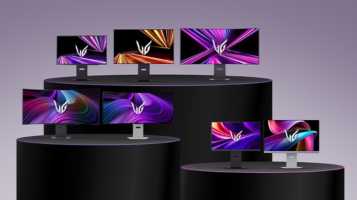 Een reeks LG UltraGear-monitoren in verschillende maten en ontwerpen, uitgestald op gelaagde zwarte podia, waarbij elk scherm levendige abstracte afbeeldingen in paarse, oranje en roze tinten laat zien.