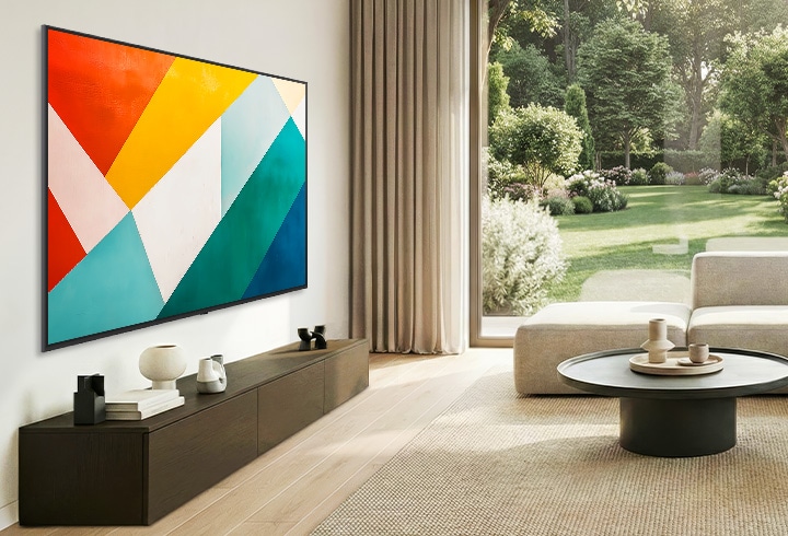 La Mini LED LG QNED evo AI QNED85 au design ultra fin est fixée au mur dans un espace de vie lumineux et ouvert et se fond à l’intérieur tout en affichant une œuvre d’art géométrique abstraite audacieuse.