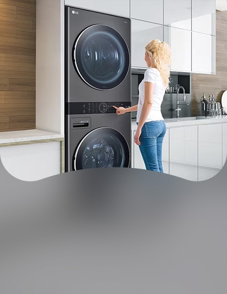 Mulher carregando roupas na lavadora de roupas LG embutida em uma lavanderia moderna.