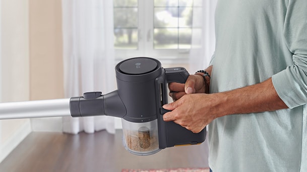 An LG stick vacuum shows a clear body view through the dust bin area.