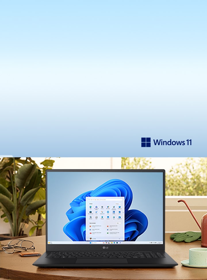 This image shows a laptop with Windows 11 displayed on a wooden desk, surrounded by plants and a lamp, evokes a serene workspace.