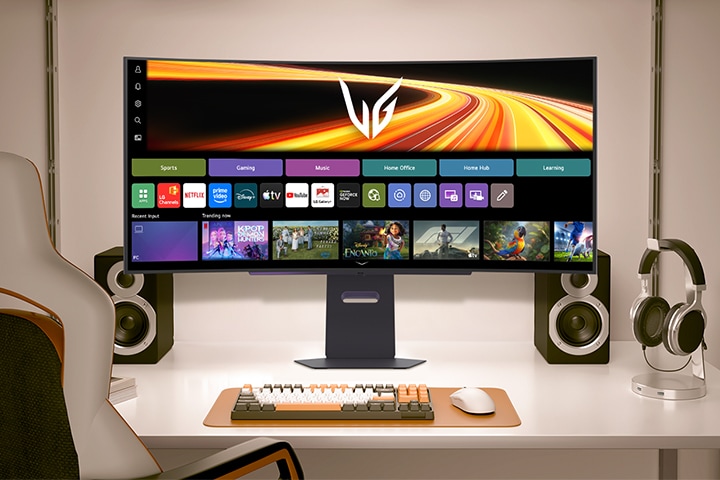 An LG UltraGear monitor on a desk setup displays a webOS dashboard featuring various apps, content recommendations, and the UltraGear logo.