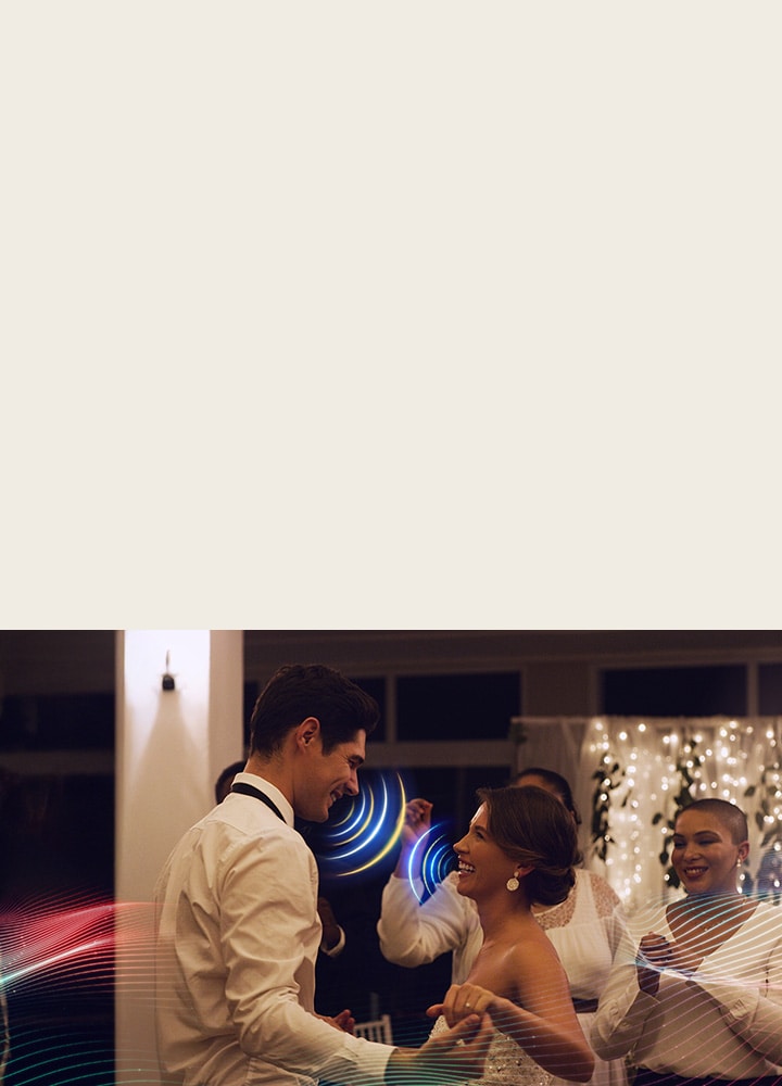 LG NANO 4K UHD AI NU85 with AI Object Remastering Pro shows a couple dancing at a lively indoor party, enhancing voices and key sounds amid surrounding music and crowd noise for clearer, more immersive audio.