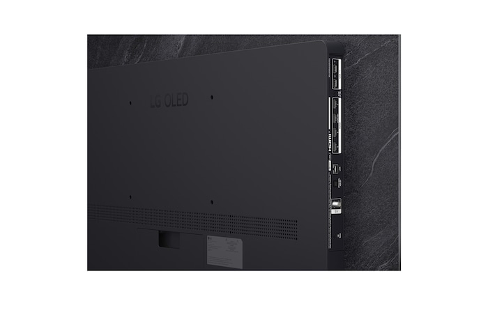 The front view of LG OLED evo AI C6, released in 2026, features a slim black bezel, with a vivid, sculpted swirl of layered rainbow tones flowing across the screen.