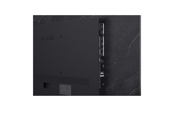 The front view of LG OLED evo AI C6, released in 2026, features a slim black bezel, with a vivid, sculpted swirl of layered rainbow tones flowing across the screen.