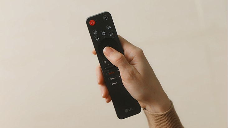 LG AI TV featuring AI Magic Remote highlights intuitive point-and-scroll navigation with a hand using the remote like a mouse, enabling easier content browsing and seamless smart TV control.