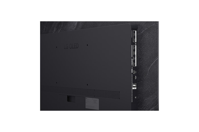 The front view of LG OLED evo AI C6, released in 2026, features a slim black bezel, with a vivid, sculpted swirl of layered rainbow tones flowing across the screen.