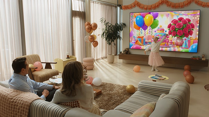 Le téléviseur LG AI, doté d’une IA générative avec Google Gemini, montre une famille assise dans une pièce décorée, tandis qu’un enfant se tient devant un téléviseur affichant des visuels de fête générés par IA par Nano Banana, notamment des ballons et des images florales.