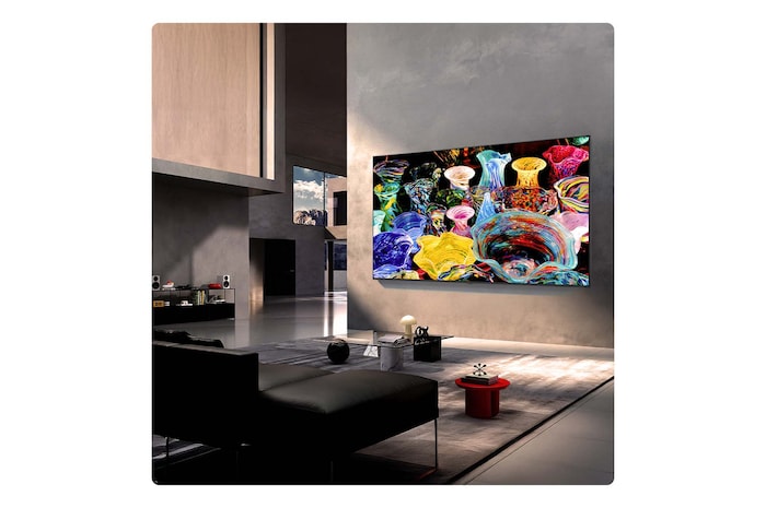 Das LG Mini RGB evo AI MRGB85 ist in einem geräumigen, modernen Wohnbereich an der Wand montiert und zeigt ein lebendiges abstraktes Kunstwerk mit wirbelnden, bunten Elementen.