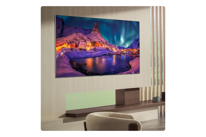 Das LG OLED evo AI G6 ist bündig an der Wand eines modernen Wohnzimmers angebracht. Es zeigt eine lebendige Aurora über einem ruhigen Küstendorf, die einem gerahmten Bild an der Wand ähnelt.