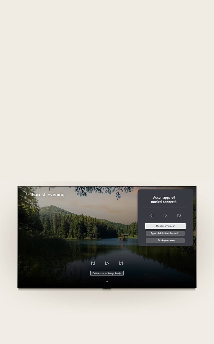 La LG Gallery+ de LG Mini RGB evo AI MRGB85 avec BGM et Music Lounge montre la scène de lac forestier « Forest Evening » à l’écran, avec un panneau d’interface utilisateur de salon de musique visible pour la musique d’ambiance, la lecture Bluetooth et les commandes.