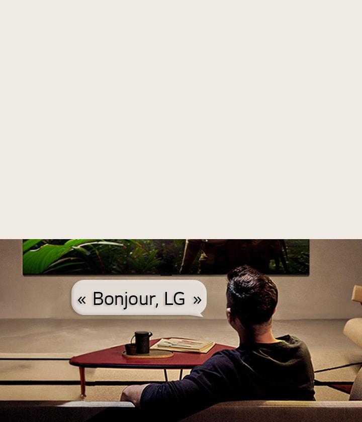 La LG OLED evo AI G6 avec reconnaissance vocale en champ lointain est activée via une commande vocale lorsqu’une personne assise dans une pièce dit « Bonjour, LG » vers le téléviseur, indiquant une interaction vocale mains libres dans l’interface du téléviseur.