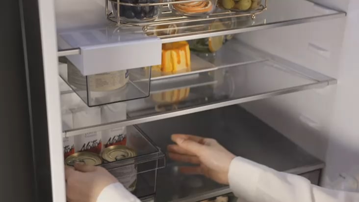 Estante plegable del refrigerador con congelador LG que se ajusta para almacenar objetos altos, como botellas.