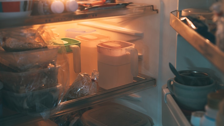 Estantes desordenados en un refrigerador LG lleno de recipientes y jarras, mostrando la necesidad de organizar para frescura y eficiencia.