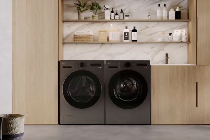 Lavadora y secadora LG instaladas en una moderna lavandería de madera con estantes, fregadero y una planta en una maceta.