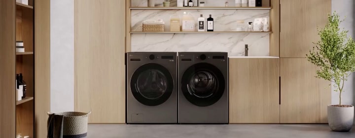 Lavadora y secadora LG instaladas en una moderna lavandería de madera con estantes, fregadero y una planta en una maceta.
