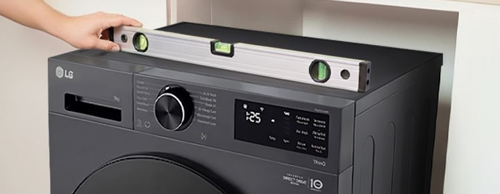 Lavadora LG alineada con un nivel de burbuja durante su instalación dentro de un gabinete empotrado