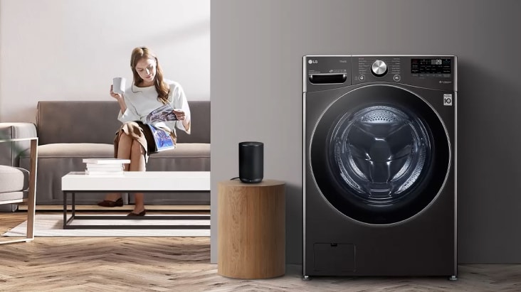 Lavadora LG junto a una mujer sentada en una sala moderna