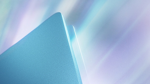 Dieses Bild zeigt eine Nahaufnahme der eleganten Metallkante eines Laptops mit einer sanften Lichtreflexion mit Farbverlauf.