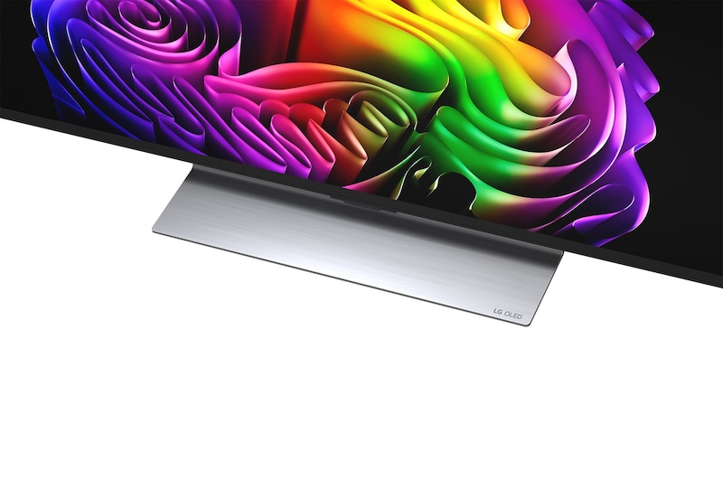 Der LG OLED evo AI G6 zeigt eine lebendige Sonnenuntergangsszene über dem Ozean, mit einer Soundbar und einem Lautsprecher unter dem Bildschirm, die einen ruhigen und stimmungsvollen Wohnbereich aufwerten.