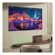 Der LG OLED evo AI G6 zeigt eine lebendige Sonnenuntergangsszene über dem Ozean, mit einer Soundbar und einem Lautsprecher unter dem Bildschirm, die einen ruhigen und stimmungsvollen Wohnbereich aufwerten.