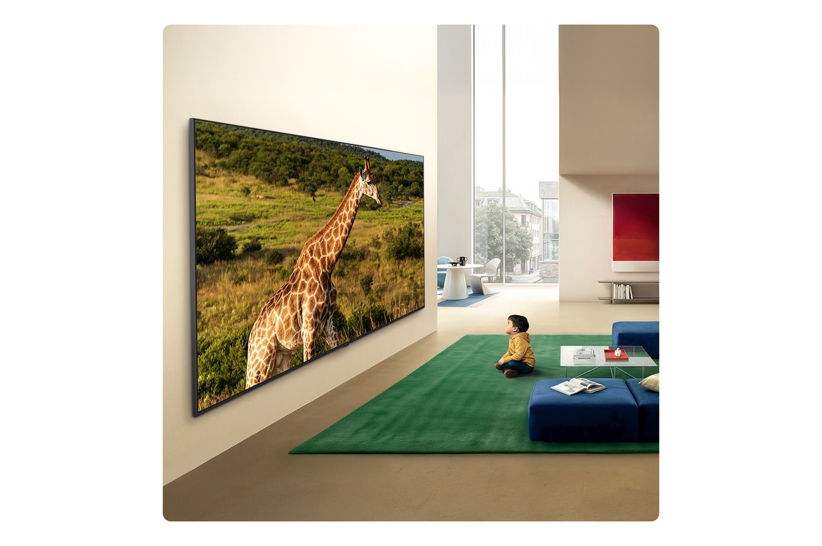 Ein in einem hellen Wohnbereich an die Wand montierter LG QNED evo AI QNED85 Mini LED Ultra Big TV zeigt eine Giraffe in einer natürlichen Landschaft mit lebendigen Details. Dadurch werden die immersive Größe und Präsenz für ein vor dem Gerät sitzendes Kind hervorgehoben.