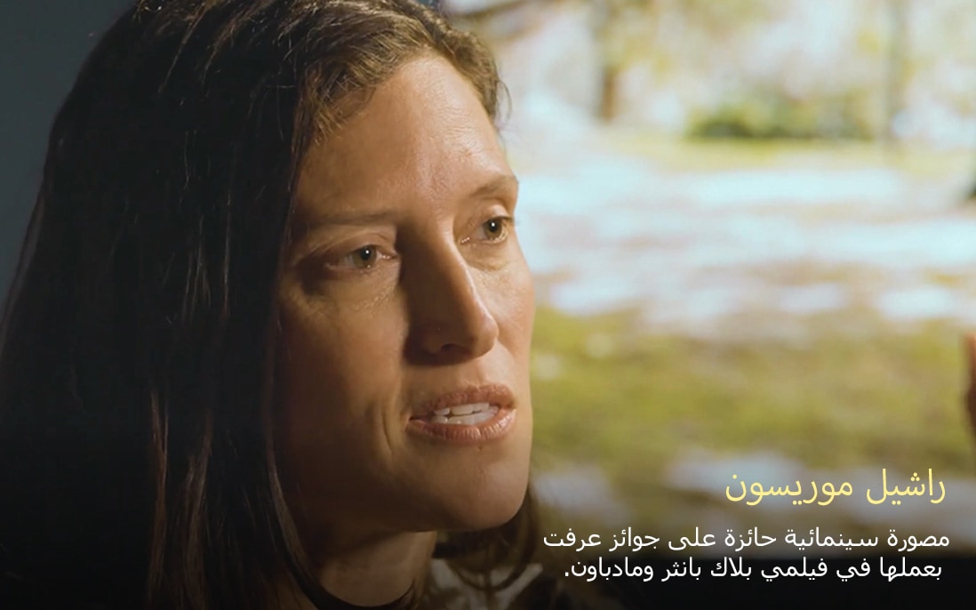 راشيل موريسون، مصورة سينمائية حائزة على جوائز عرفت بعملها في فيلمي بلاك بانثر ومادباوند، تتحدث في أجواء دافئة بإضاءة ناعمة، مما يعكس أجواء احترافية ومتأملة.
