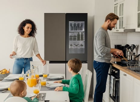 Family enjoying in modern kitchen with LG InstaView refrigerator while parents cook and children sit at table.	