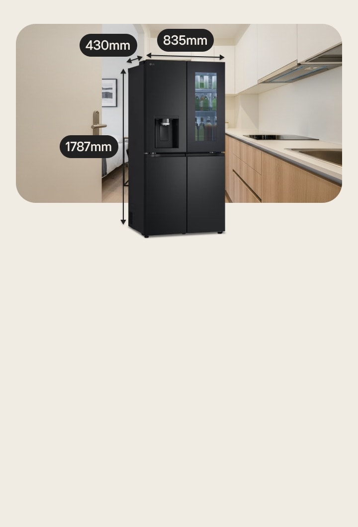 Réfrigérateur congélateur LG noir de taille moyenne avec porte InstaView et distributeur d’eau. Derrière, un lit est à gauche et une cuisine avec une plaque de cuisson à induction à droite.