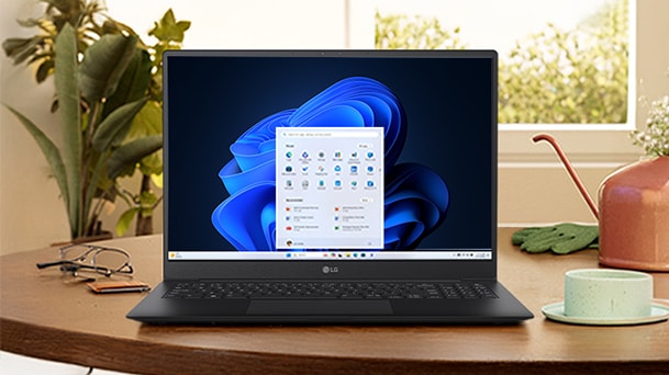 Cette image montre l’ordinateur portable sur un bureau en bois entouré de plantes et de lampes avec le texte « Facile à déployer, compatible et rentable ».