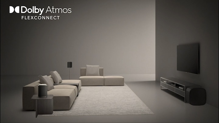LG OLED evo AI W6 Wallpaper TV Sound Suite with DAFC (Dolby Atmos FlexConnect) shows a wide room where the TV and wireless speakers are freely positioned, conveying immersive Dolby Atmos audio optimized for flexible speaker placement.