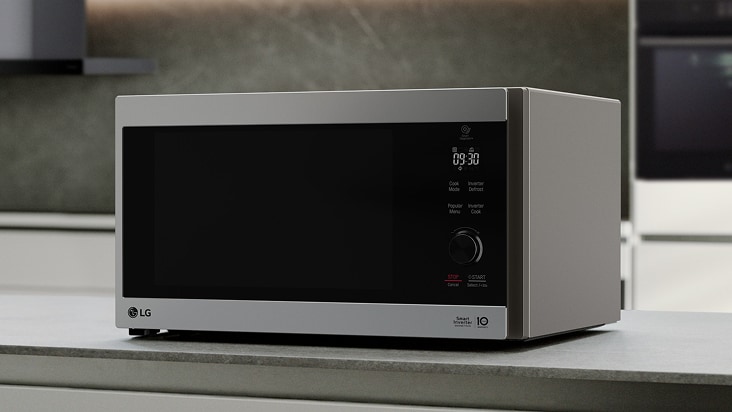 A silver LG countertop microwave with a glass door and right-side dial sits on a gray kitchen counter.