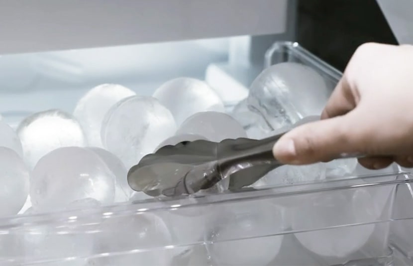 LG refrigerator ice maker with easy access ice storage and removal using tongs.