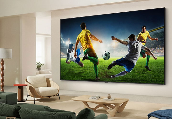 LG TV featuring AI Super Upscaling is displayed on the wall in a contemporary living room, showcasing a dynamic soccer match upscaled to vivid 4K resolution with enhanced color and detail for immersive viewing.
