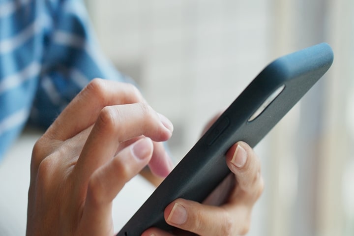 Persona che utilizza uno smartphone per accedere e controllare le funzioni del frigorifero intelligente da remoto tramite l’app LG ThinQ	