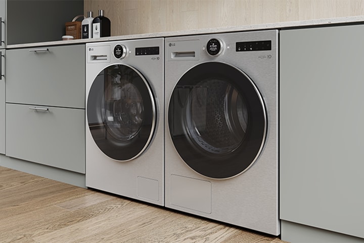 Lavatrice e asciugatrice LG installate fianco a fianco in un armadio integrato, mostrato in una moderna lavanderia.	
