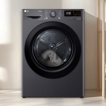 Asciugatrice nera LG installata sotto un piano di lavoro in una zona lavanderia. La porta trasparente mostra il bucato all’interno, chiaramente visibile attraverso la parte frontale della macchina.