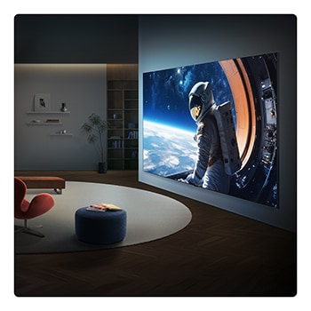Сверхбольшой телевизор LG QNED evo AI QNED85 Mini LED закреплен на стене в современной гостиной, отображая на широком экране крупномасштабную сцену с астронавтом, которая визуально заполняет комнату и создает сильный кинематографический эффект.