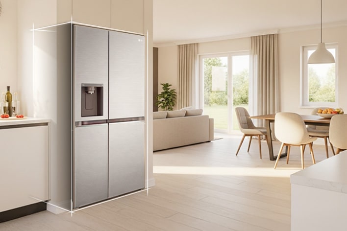 Intérieur de cuisine couleur beige vif avec réfrigérateur congélateur LG argenté intégré sur le côté gauche. À droite, une table de salle à manger avec des fleurs placées dessus complète la scène.