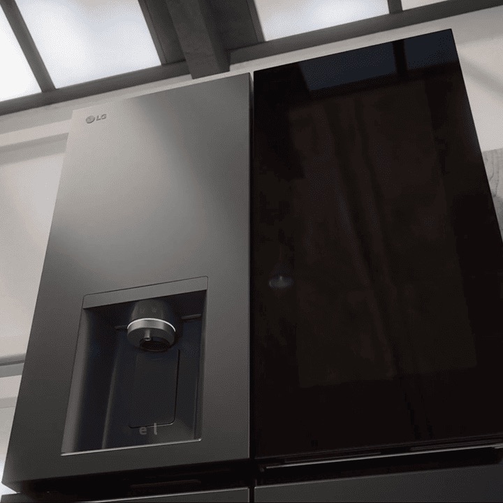 Gros plan du réfrigérateur InstaView de LG. Le panneau transparent s’allume, suivi du distributeur d’eau. La poignée élégante est montrée avant que la porte ne s’ouvre.