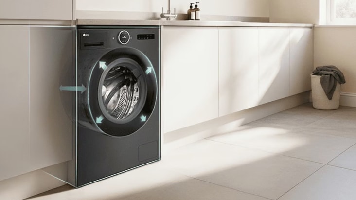 Lavadora de carga frontal LG empotrada en muebles de cocina, flechas que indican el tamaño del tambor y una moderna sala