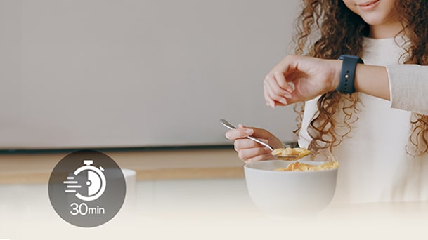 Símbolo de temporizador de 30 minutos sobre una escena de cocina luminosa, con una persona sirviendo cereal de un tazón blanco con una cuchara.