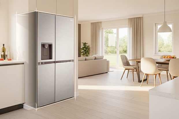 Interior de cocina en tonos beige claro con un refrigerador con congelador LG plateado empotrado en el lado izquierdo. A la derecha, una mesa de comedor con flores colocadas encima completa la escena.